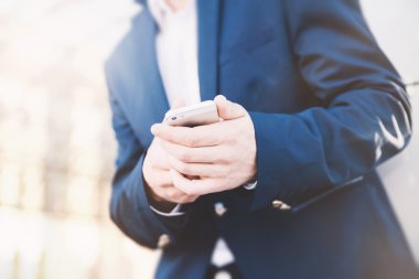 İş adamı elinde telefonla.