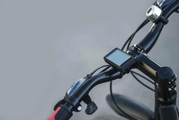 Ein Mountainbike-Lenker mit Tacho und Klingel mit Fahrradhandbremse auf grauem Hintergrund — Stockfoto