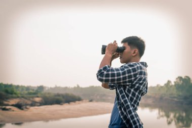 Dürbün deniz kenarı boyunca görünen turist adam.