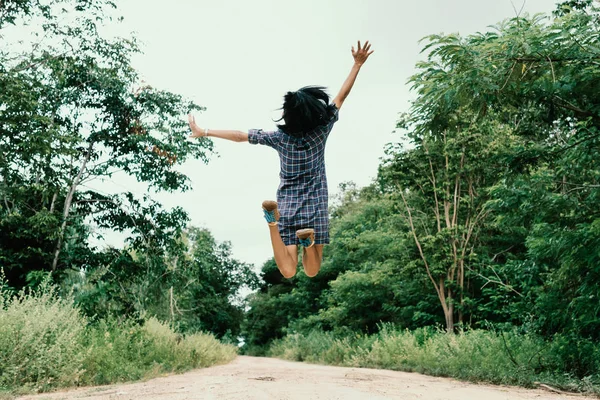 Mutlu kız ormanda yolda atlama.