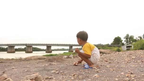 Χαριτωμένο μικρό ασιατικό αγόρι παίζει με ξύλινα αεροπλάνο κοντά στον ποταμό — Αρχείο Βίντεο
