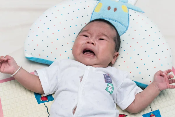 Cute baby noworodka leży i płacze na łóżku — Zdjęcie stockowe