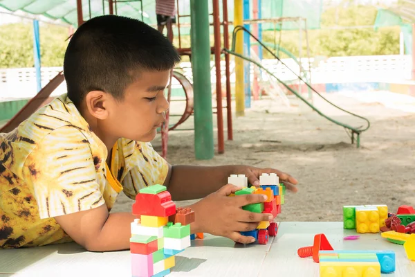 Маленький ребенок азиатский мальчик играть строительный кирпич на детской площадке — стоковое фото