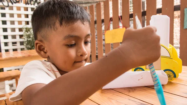 Мила дитина азіатський маленький хлопчик думає і пише на папері — стокове фото