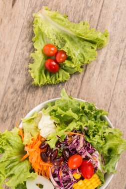 ahşap zemin üzerinde sebze salatası