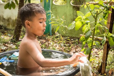 Splash su Havzası içinde yıkanırken oynayan sevimli küçük çocuk