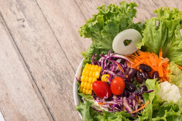 Salade de légumes sur fond bois — Photo