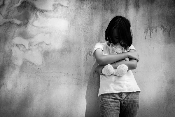 Triste asiático menina sozinho com branco urso perto de idade parede cimento — Fotografia de Stock