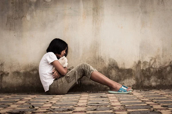 Triste asiático chica solo con blanco oso cerca viejo pared cemento — Foto de Stock