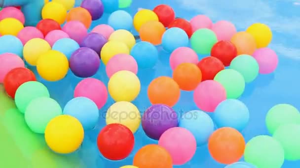 Floating color children's ball on water in swimming pool — Stock Video