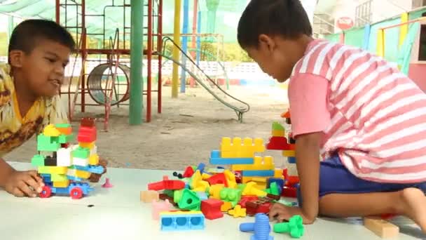 Malý roztomilý chlapec asijské hrát s plastových stavebních bloků v parku