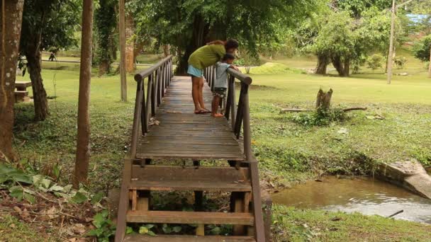 Feliz familia madre e hijo relajación en el viejo puente de madera — Vídeo de stock