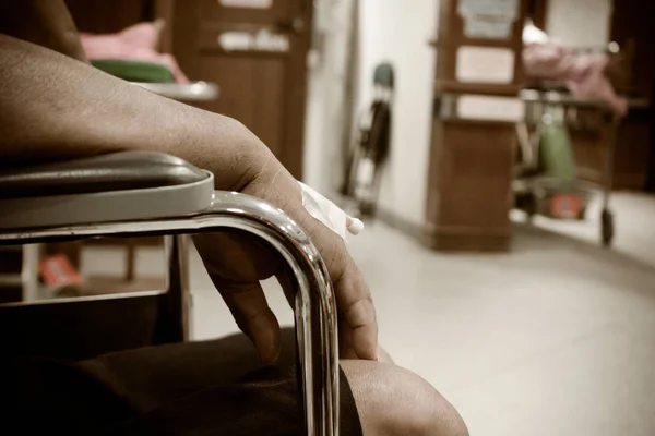 Paciente sentado em cadeira de rodas em tom vintage hospital — Fotografia de Stock