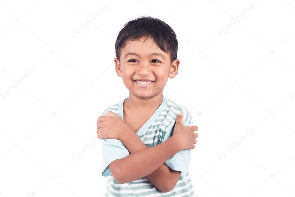 Cute asian little boy crossed one arms and smile
