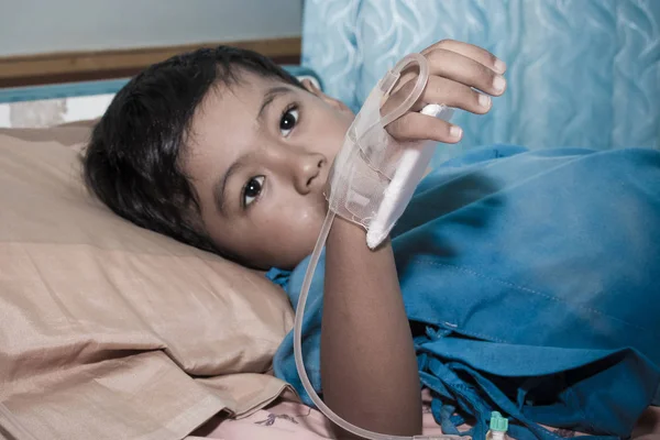 Little boy sick lying on patient  bed,hand in saline