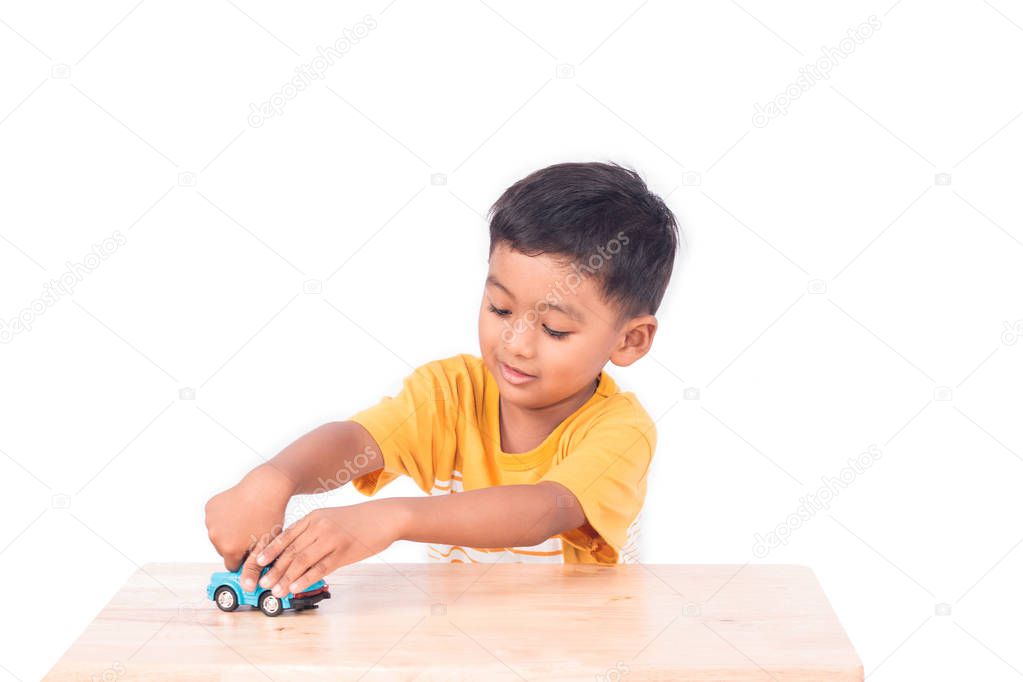 Cute asian boy play toy blur car 