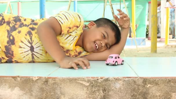 Милый маленький азиатский мальчик, играющий с автомобильной игрушкой — стоковое видео
