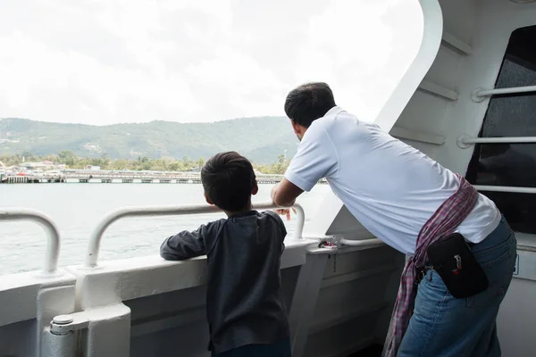Счастливый отец и его сын смотрят на море на корабле — стоковое фото