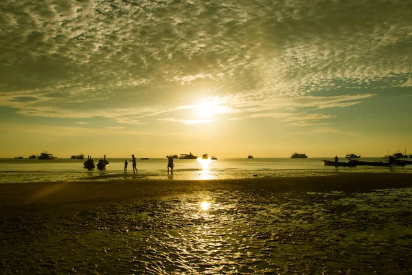 Les gens marchant sur la plage coucher de soleil fond — Photo