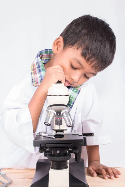 Lindo asiático poco estudiante chico trabajo con microscopio —  Fotos de Stock