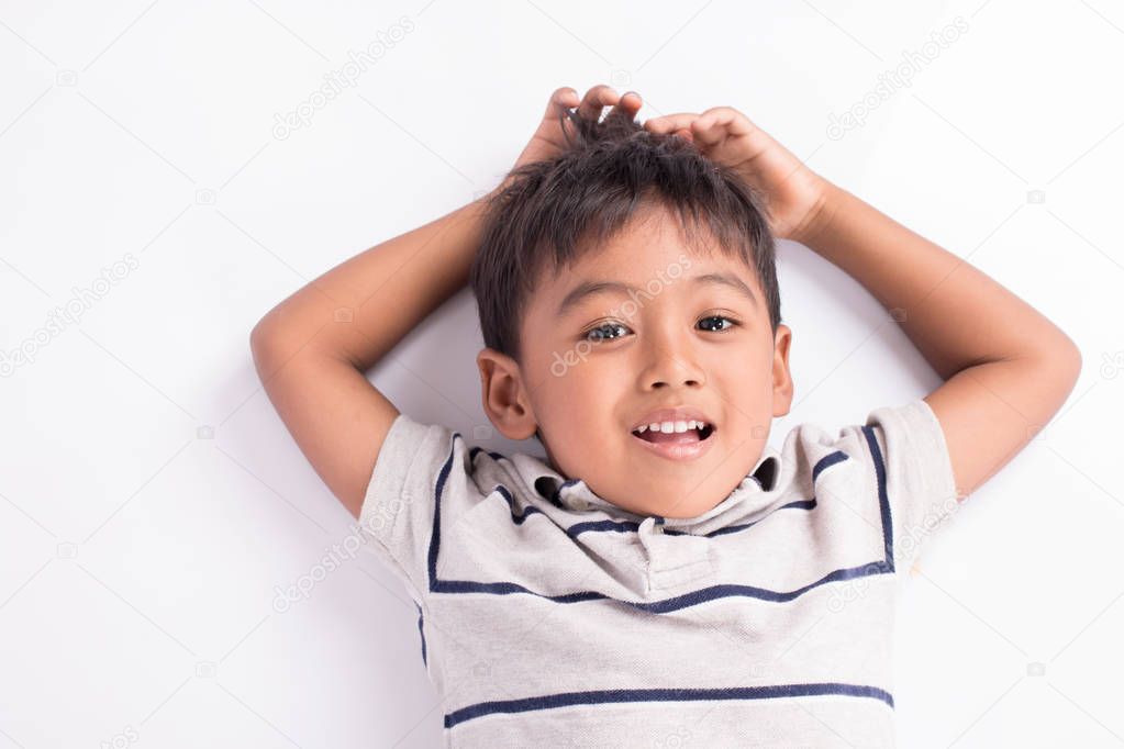 close up of cute asian boy lying on floor 