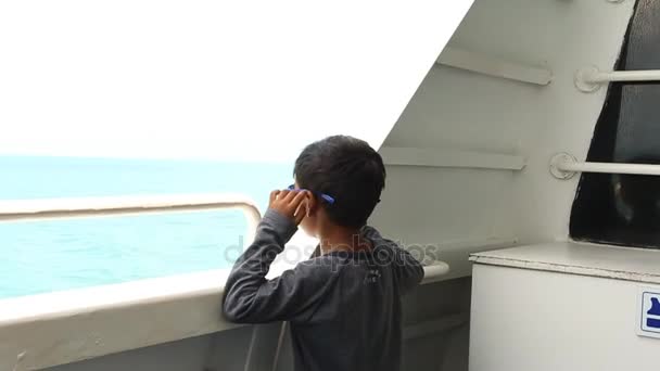 かわいいアジアの少年の船で海を見ています。 — ストック動画