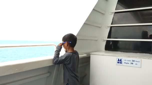 Roztomilý chlapec asijské pohledu moře na lodi — Stock video
