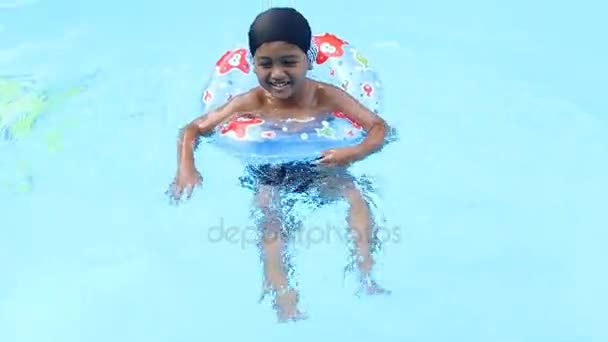 Милый маленький мальчик плавает в бассейне — стоковое видео