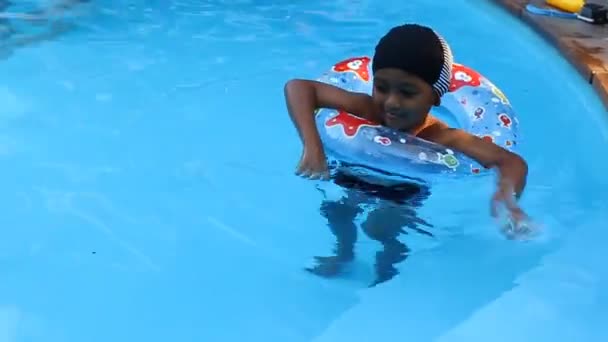 Милый маленький мальчик плавает в бассейне — стоковое видео