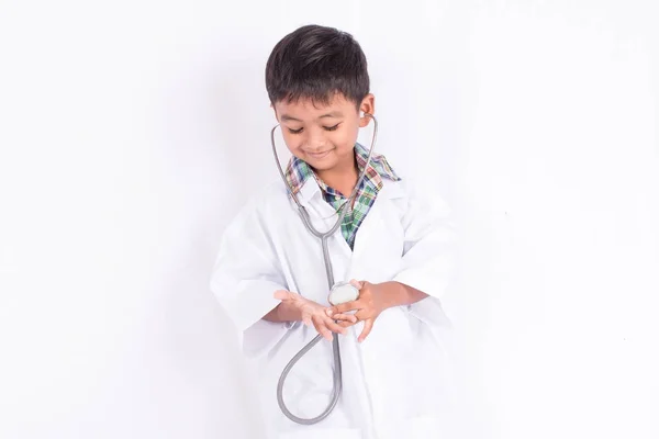 Mignon asiatique petit garçon portant un docteur manteau sur blanc fond — Photo