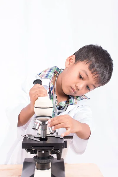 Roztomilý asijský student chlapeček práce s mikroskopem — Stock fotografie