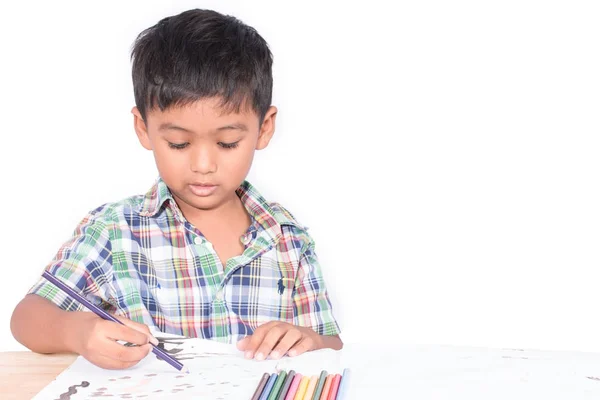 Милий маленький хлопчик малює на малюнку книги — стокове фото