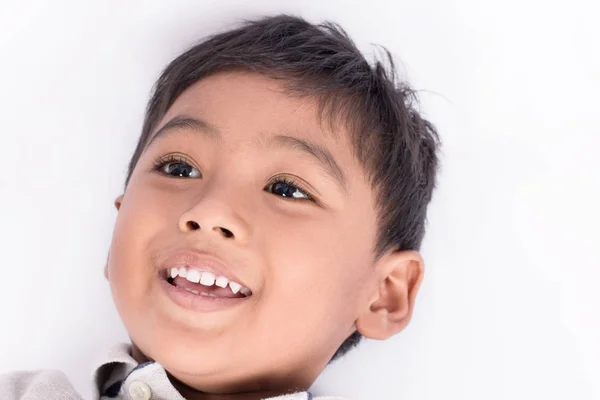 Primer plano cara lindo niño mintiendo y sonrisa —  Fotos de Stock