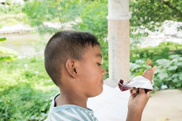 Милый азиатский мальчик ест мороженое — стоковое фото
