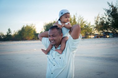 Mutlu baba ve oğul plajda oyna