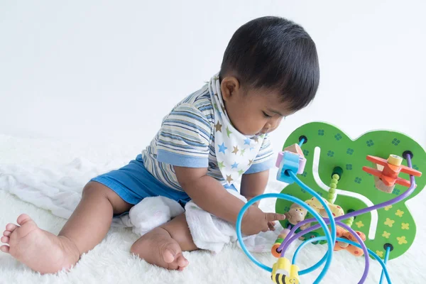 Lindo asiático bebé sentado y jugar madera juguetes — Foto de Stock