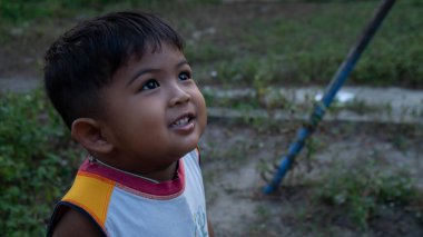 Küçük sevimli Asyalı çocuk gülümsüyor.