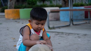 Parkta oynayan sevimli Asyalı çocuk.