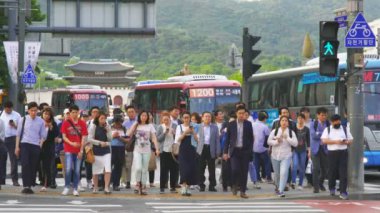 Gwanghwamun Plaze arka planda, Seul, Güney Kore 'de yoğun saatlerde yürüyen bir kalabalık.