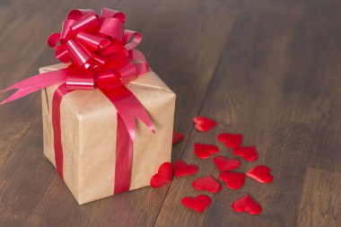 Kırmızı kurdeleli geri dönüşümlü kağıda sarılmış hediye kutusu 