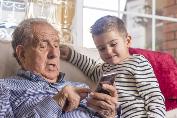 Avô e neto procurando um telefone inteligente — Fotografia de Stock