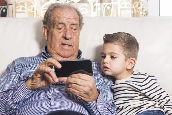 Avô e neto procurando um telefone inteligente — Fotografia de Stock