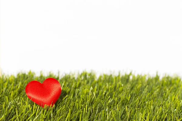 Карточка любви, украшенная сердцем на зеленой траве — стоковое фото