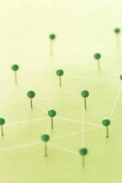 Grren καρφίτσες σε πράσινο φόντο τη δημιουργία ενός δικτύου — Φωτογραφία Αρχείου
