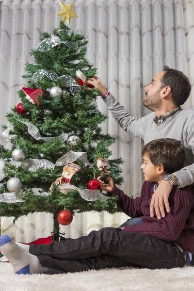 Happy father and son decorating Christmas tree