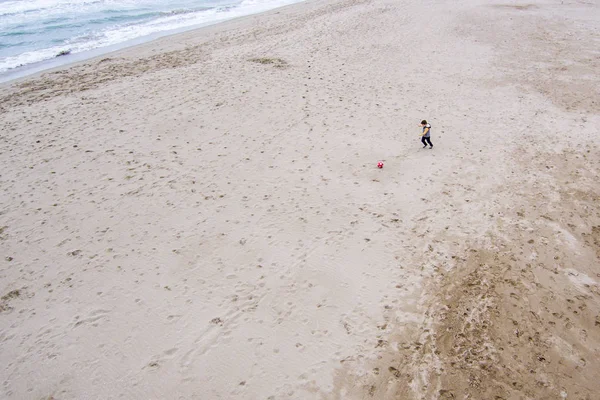 Niño jugando con una pelota en la playa — Foto de Stock