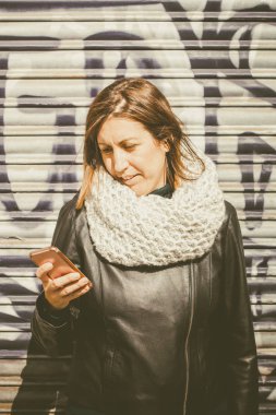 Bir akıllı telefon kullanan orta yaşlı kadın