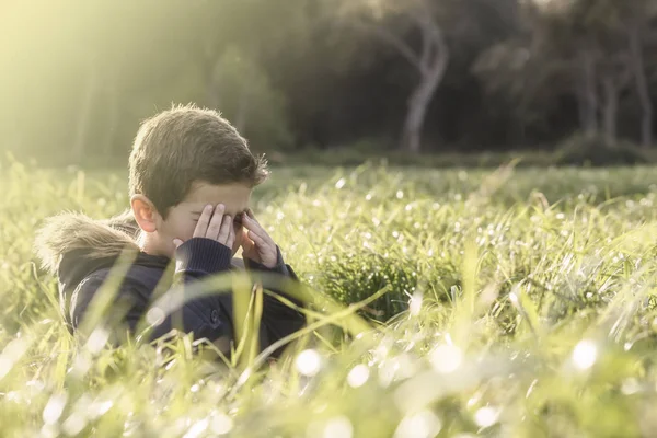Boy playing hide and seek in the field — Stock Photo, Image