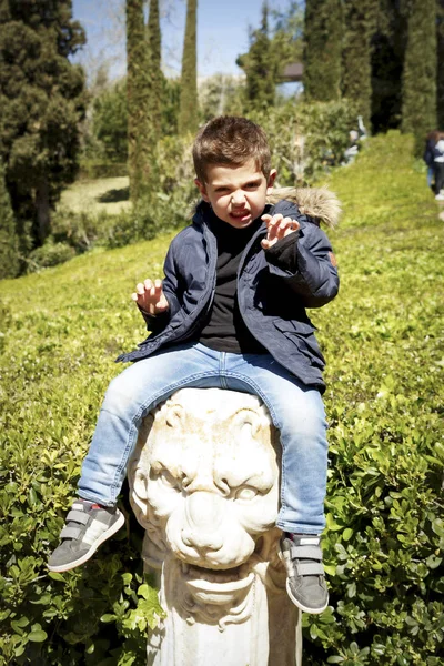 Criança sobre a escultura de um leão — Fotografia de Stock