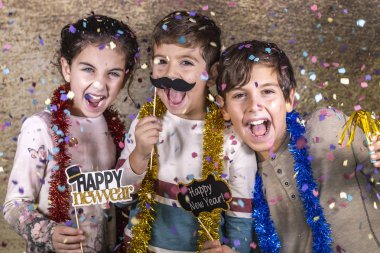 Thre happy kids celebrating new year eve at home clipart